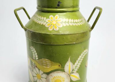 Green vintage milk can with floral design.