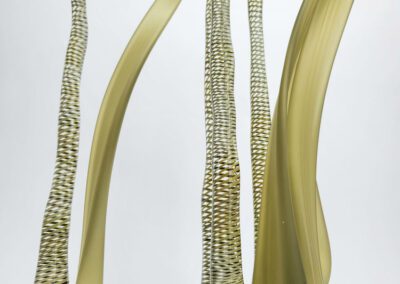 Tall, slender yellow glass sculptures on display.
