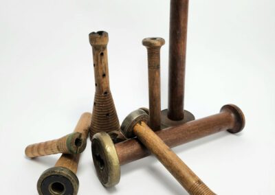 Vintage wooden textile spools on white background.