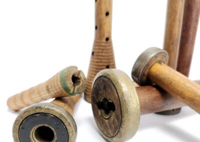 Wooden textile bobbins arranged on white background.
