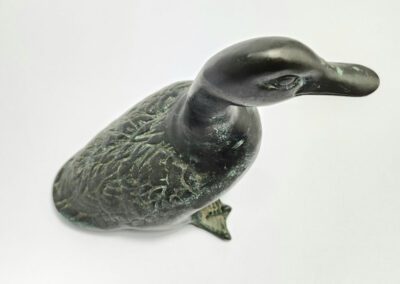 Bronze duck figurine on white background.