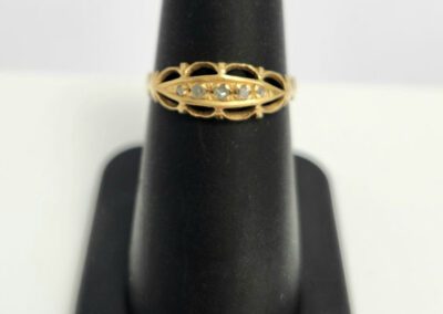 Gold ring on black display stand.