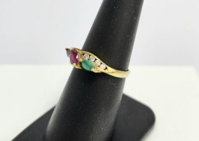 Gold ring with colorful gemstones on display.