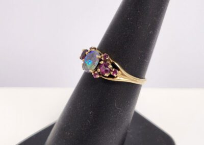 Gold ring with opal and red stones.