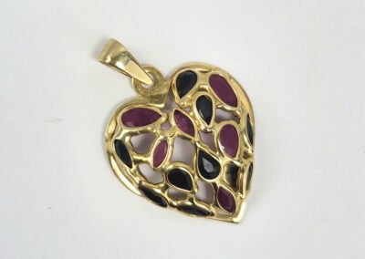 Heart-shaped gold pendant with colorful stones.