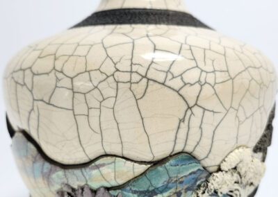 Cracked ceramic vase with colorful textured patterns.