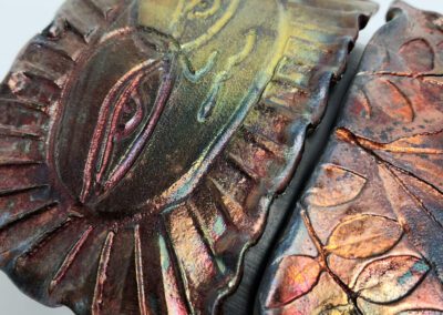 Colorful embossed design with eye and leaves.