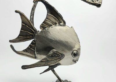 Metallic fish sculpture on spherical base.