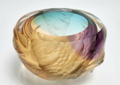 Colorful, textured glass bowl with gradient hues.