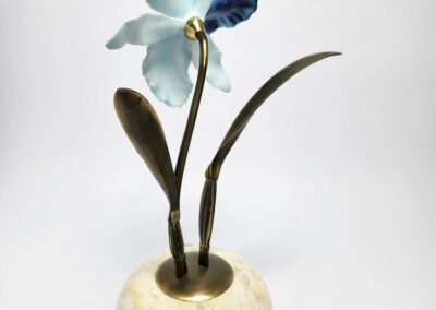 Orchid sculpture in marble and metal vase.