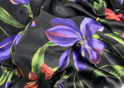 Colorful floral pattern on black fabric background.