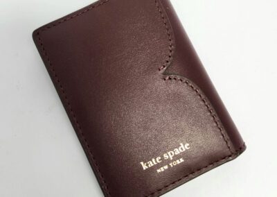 Maroon Kate Spade wallet on white background.