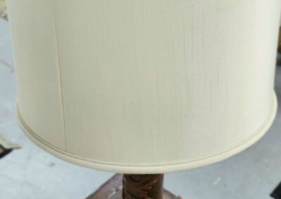 Ornate table lamp with white lampshade.