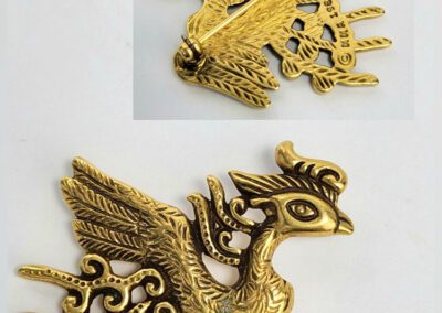 Golden phoenix brooch with intricate details.
