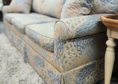 Patterned sofa with decorative cushions and table.