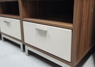 Wooden nightstand with white drawer and handle.