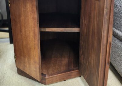 Wooden cabinet with open door, empty inside.