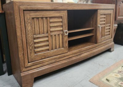 Wooden cabinet with sliding doors and shelves.