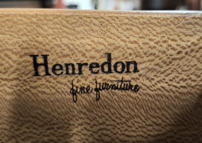 Henredon fine furniture logo on wood surface.