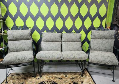 Three cushioned chairs against a patterned wall.
