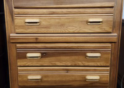 Wooden chest of drawers with five handles.