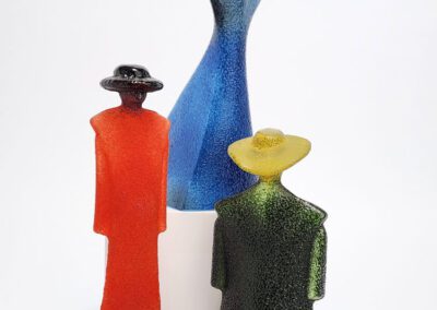 Colorful abstract glass figures with wide-brimmed hats.