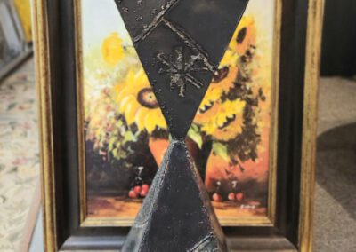 Geometric sculpture with framed painting background.
