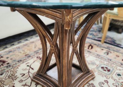 Glass-top table with wooden ornate base.