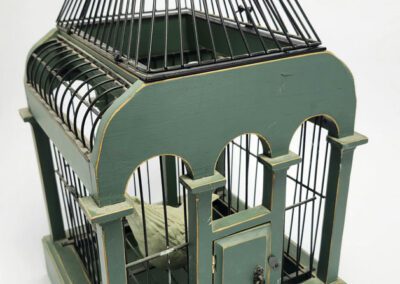 Green vintage birdcage with ornate design.