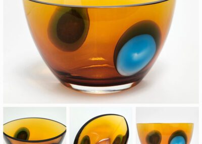 Amber glass bowl with colorful circular patterns.