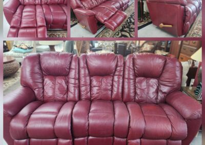Red leather reclining sofa set on display.