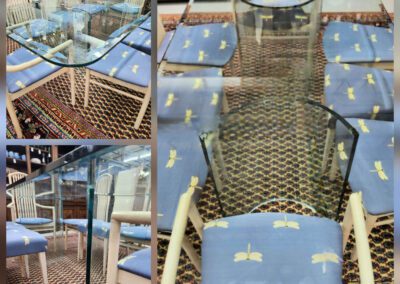 Glass dining table with blue cushioned chairs.