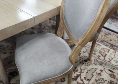 Wooden chair by dining table on rug.