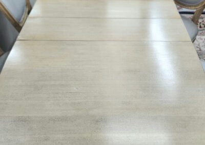 Wooden oval dining table with chairs around.