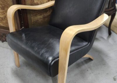 Black chair with wooden armrests.