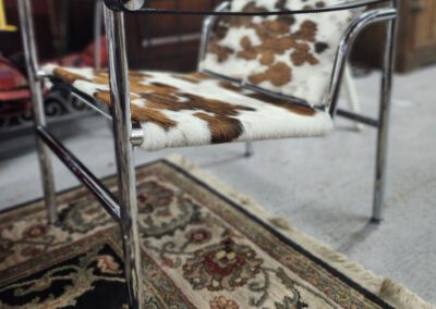 Cowhide chair on patterned rug.