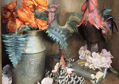 Rooster figurine with flowers and farmhouse decor.
