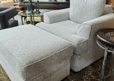 Light gray upholstered armchair with matching ottoman