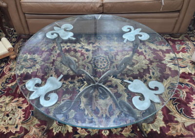 Round glass coffee table with fleur-de-lis base