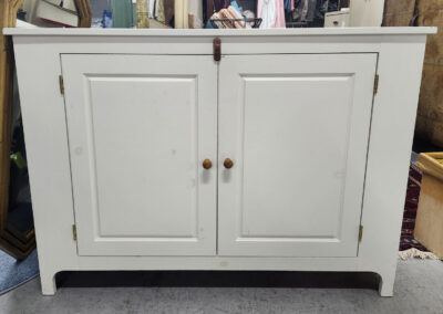 White two-door cabinet with wooden knobs