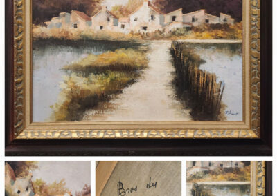 Framed landscape painting of village by water