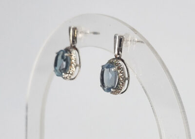 Silver earrings with blue oval gemstones and diamonds