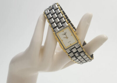 Two-tone rectangular wristwatch on mannequin hand