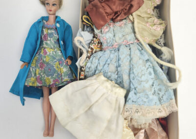Vintage doll with box of assorted clothes