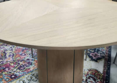 Round wooden dining table with pedestal base