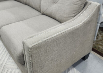 Light gray upholstered sofa with nailhead trim