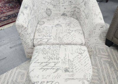 White script-pattern armchair with matching ottoman