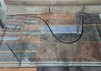 Curved glass coffee table on patterned rug