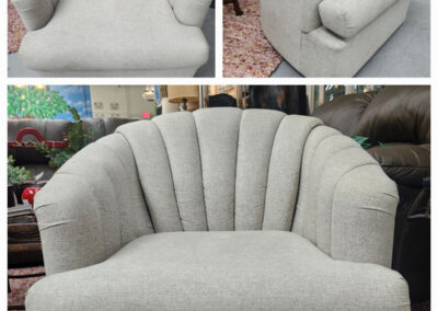 Light gray channel-back upholstered barrel chair