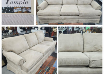 Beige three-seater rolled-arm skirted sofa